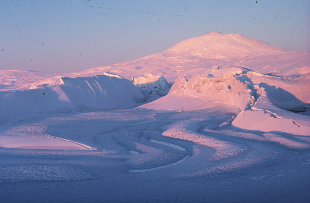 Pink midnight sunlight on Scott Base pressure ridges and Mt Erebus ...