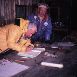 Lord Elworthy signing the visitor's book in the Cape Royds Hut