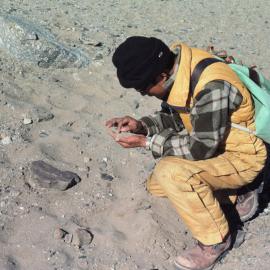 Chinese guest scientist, Zhang Fu Yuan examines sand sample from creek draining Lake Thomas