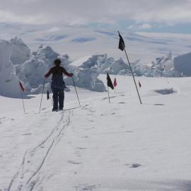 Person in foreground walking towards dramatic ice shapes in middle distance