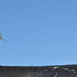 Wind turbines on the skyline, with the US & NZ flags
