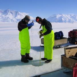 Ken Ryan and Doug Henderson checking the ice thickness after drilling the hole
