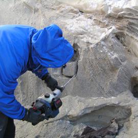 Warren Dickinson drills out a sample of permafrost from a stream cut in Lower Victoria Valley