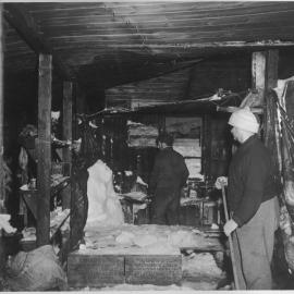 Interior of hut showing lining and boxes embedded in the ice: Eric Gibbs in foreground