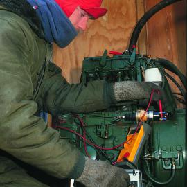 Bruce Calder w/o electrician fixing engine in unheated hut
