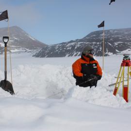 Digging out a high-precision GPS reciever being used to calibrate the Scott Base tide gauge.