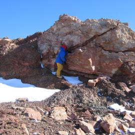 Geologist studying volcanic rock formations in the Coombs Hills
