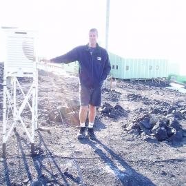 Evan Baddock beside thermometer screen Scott Base