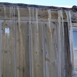 Icicles hang from the outside wall of Discovery Hut