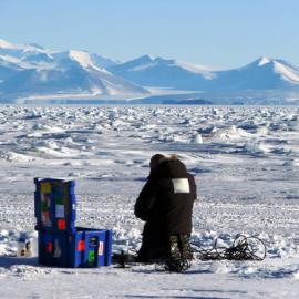 Andrew McMinn preparing a bottle for the collection of sea water under the sea ice