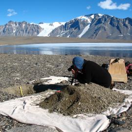 Jim Bockheim photographing a soil pit. "Camp Lake" and the Asgard Range are in the background. Eastern Taylor Valley.