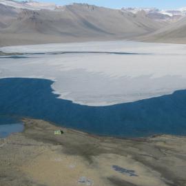 Aerial of Lake Vanda with partially melted ice cover and the Vanda hut (refuge)
