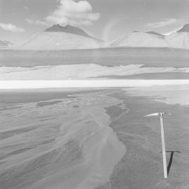 Melt water stream arising from snow cirque flowing across water-laden gravels to Lake Vida