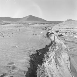 Frozen stream flowing from snow cirque