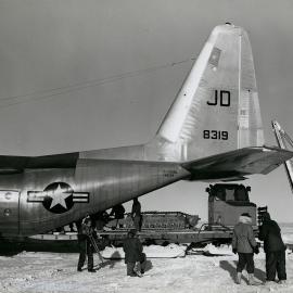 The cab and tracks of The Peter snow miller being unloaded from a VX-6 C-130 at Byrd Station 