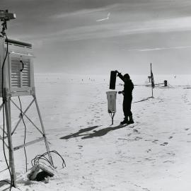 A weather observer is shown operating a snow trap