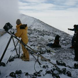 Scientists examining a camera on Mt Erebus Crater rim