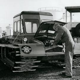 N Clark inspecting a new Snow-master before sending it to Scott Base