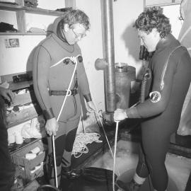 Gary Housley| prepares to dive| assisted by| John Montgomery| Steve Mercer
