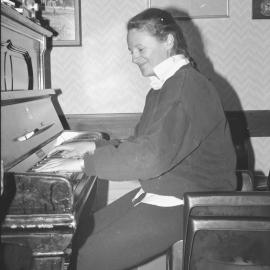 Biddy practising piano in the bar