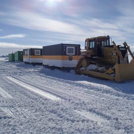 The Antarctica New Zealand dozer moving AHT conservation containers across the sea ice from Cape Evans to their new location at  Hut Point