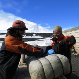 AHT Conservators Josiah Wagener and Nicola Dunn in the process of re-wrapping a 100 year old pony fodder bale at Terra Nova Hut, Cape Evans