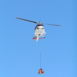 Helicopter Arriving with a Skidoo in a Sling