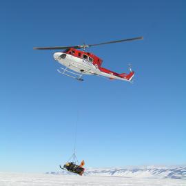 Helicopter Arriving with a Skidoo in a Sling