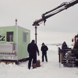 Hole drilling the fish hut hole near the ice runway