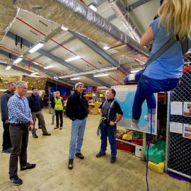 U.S. Secretary of State John Kerry watches a researcher practicing emergency rappelling tactics as the Secretary toured Scott Base,