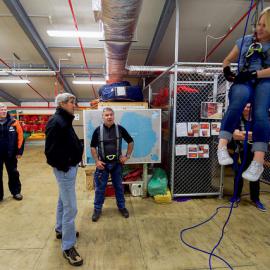 U.S. Secretary of State John Kerry watches a researcher practicing emergency rappelling tactics as the Secretary toured Scott Base,