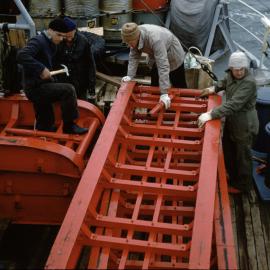 Men with sleds onboard ship