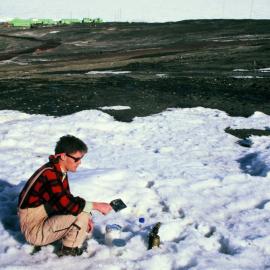 Rob sampling snow on slopes behind Scott Base